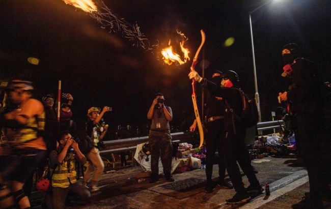 홍콩 중문 대학에서 불이 붙은 화살을 날리고 있는 시위 참가자.