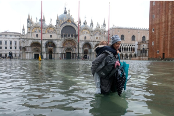 '물의 도시' 베네치아의 산 마르코 광장이 물에 잠겨 있는 가운데 모녀가 광장을 건너고 있다. 사진=로이터