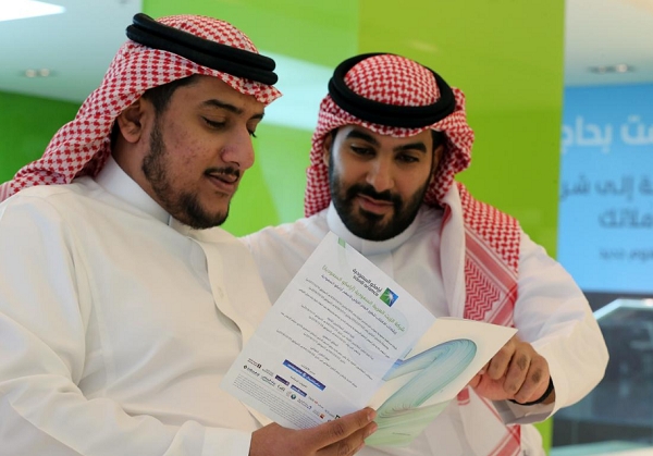 사우디아라비아의 개인투자자들이 17일(현지시간) 사우디 리야드에서 아람코의 IPO를 소개한 팜플랫을 보고 있다. 사진=로이터