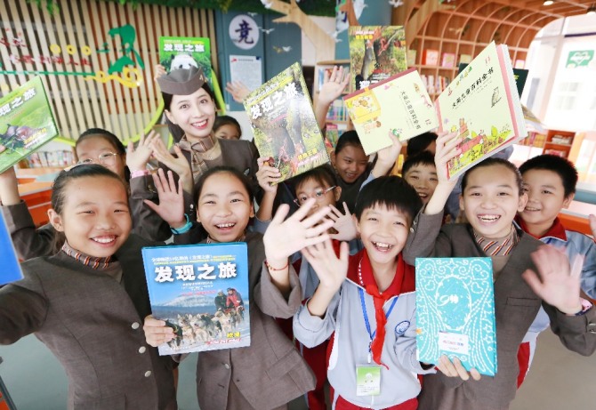 아시아나항공 승무원이 21일 중국 하이커우시 '시후실험학교'에서  '아름다운 교실' 자매결연 행사에 참석한 후 시후실험학교 아이들과 함께 기념촬영을 하고 있다. 사진=아시아나항공