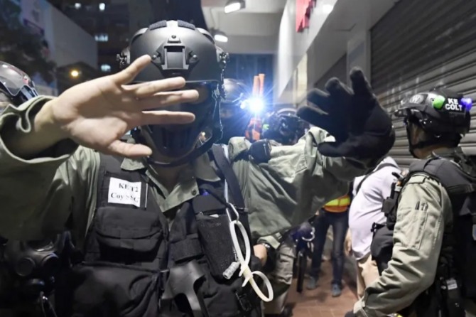 홍콩 경찰관들이 시위대를 단속하면서 취재 카메라를 제지하고 있다.