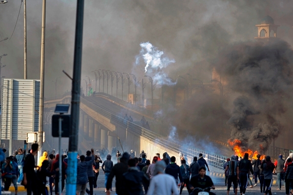 28일(현지시간) 이라크 나자프에서 반정부 시위대가 최루탄을 쏘는 보안군과 대치하고 있다. 사진=뉴시스