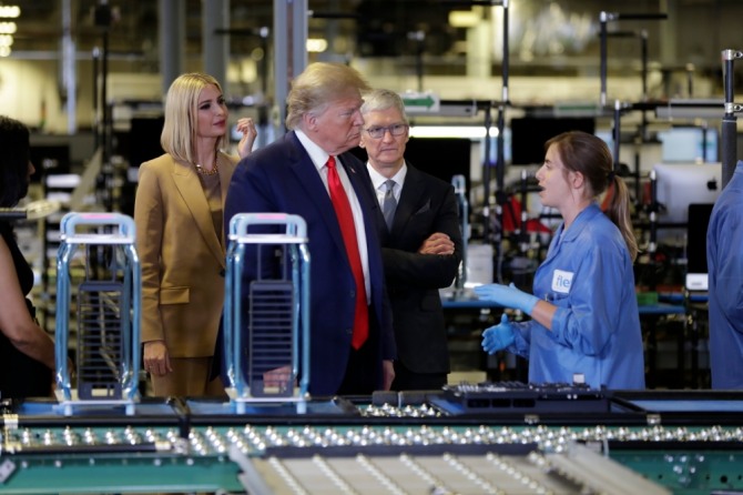 도널드 트럼프 미국 대통령이 지난달 20일(현지시간) 미 텍사스주 오스틴의 애플 공장을 방문해 팀 쿡 애플 최고경영자(CEO), 이방카 트럼프 백악관 선임 보좌관 등과 생산 라인을 둘러보며 직원과 얘기를 나누고 있다. 사진=뉴시스