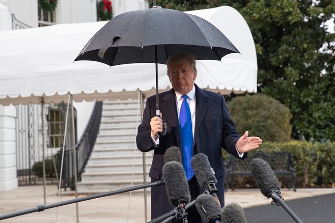 도널드 트럼프 미국 대통령이 2일(현지시간) 나토(NATO·북대서양조약기구) 정상회의 참석차 영국 런던으로 떠나기에 앞서  백악관에서 우산을 든 채 취재진 질문에 대답하고 있다.  워싱턴=AP/뉴시스