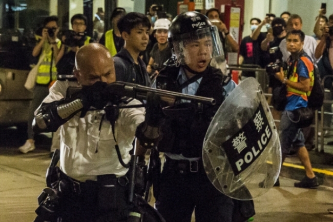 홍콩경찰이 항의시위를 벌이는 시민들을 향해 총을 겨누고 있는 모습.