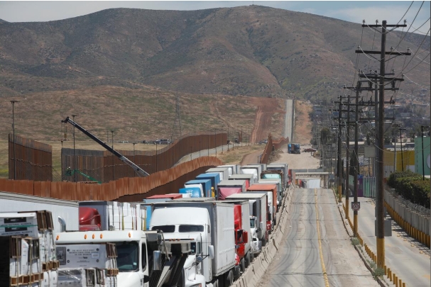 멕시코 티후아나에서 미국으로 건너 오기 위해 트럭이 긴 줄을 서서 기다리고 있다. 사진=로이터