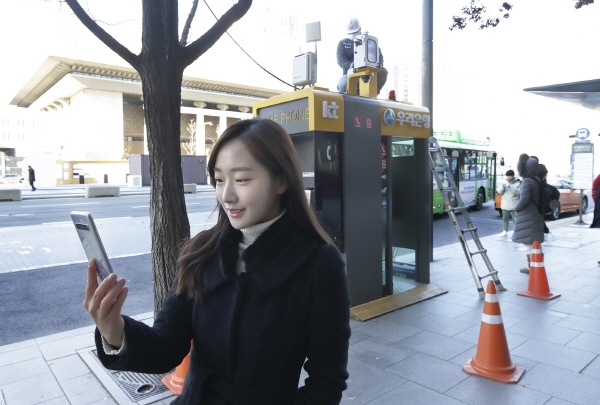 KT가 전국 2000여 곳에 자체 구축한 미세먼지 측정기를 환경부 인증 장비로 교체해 더욱 신뢰도 높은 공기질 정보를 제공한다. 서울 광화문에 교체 설치된 측정소 앞에서 KT 홍보모델이 에어맵코리아를 홍보하고 있다. 사진=KT