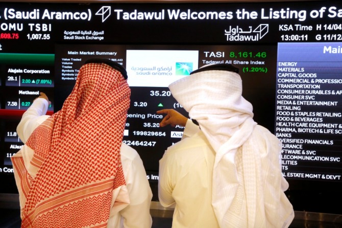 사우디아라비아 국영 석유회사 아람코 거래 첫 날 시민들이 전광판을 살펴보고 있다. 사진=뉴시스