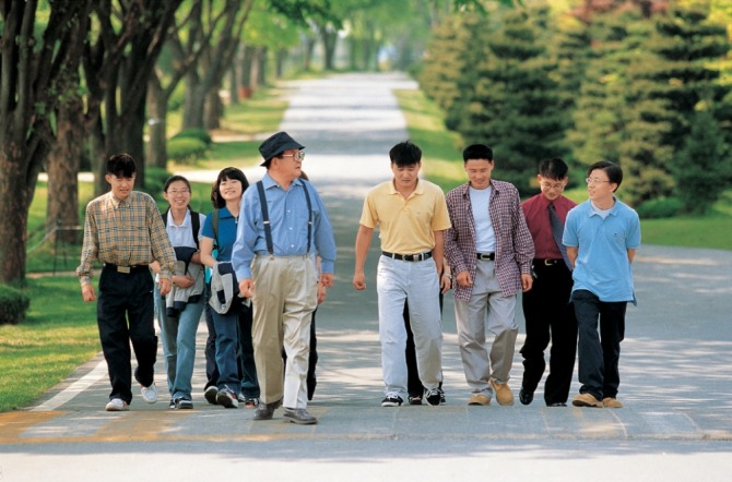 구 명예회장(가운데)이 연암대학교에서 학생들과 함께 교내를 산책하고 있다