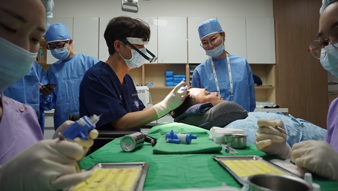 ETRI 연구진이 개발한 기술을 바탕으로 경북대 김문규 교수팀이  이 기술을 실제 두발 이식 수술에 활용을 하고 있는 모습. 사진=ETRI
