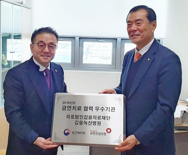 (오른쪽부터)황민한 경영원장, 이건형 국민건강보험공단 부산북부지사 부장이 인증 현판을 들고 기념 사진을 찍고 있다. 사진=KBI그룹