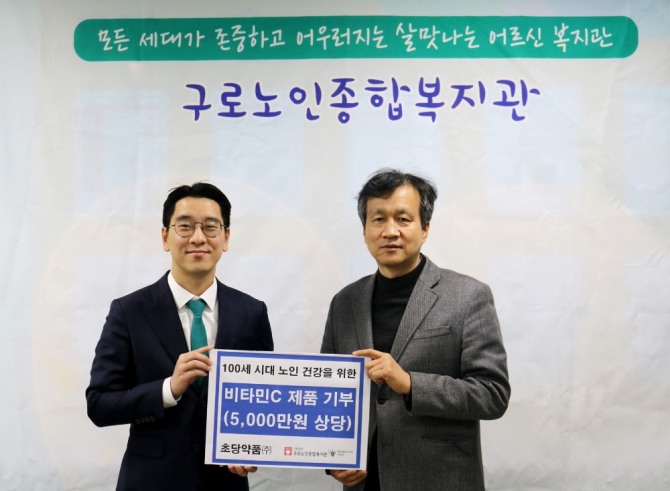 김우석(왼쪽) 초당약품㈜ 전무와 조흥식 구로노인종합복지관장이 비타민C 제품 전달식을 열고 기념촬영을 하고 있다. 사진=초당약품