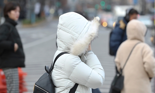 월요일인 13일은 전국이 대체로 맑은 가운데 아침과 낮 일교차가 커 감기 등 건강관리에 유의해야 한다.  한 여성이 12일 서울 광화문 네거리에서 추위를 피해 모자를 쓰고 걸어가고 있다.   사진=뉴시스