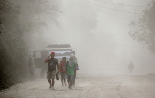 13일(현지시간) 필리핀 바탕가스 지역주민들이 인근의 탈 화산이 폭발하자 연기와 화산재를 피해 안전지대로 이동하고 있다.