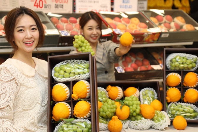 이마트 용산점 농산매장에서 모델들이 샤인머스켓과 한라봉이 담긴 '샤봉세트'를 소개하고 있다. 사진=이마트