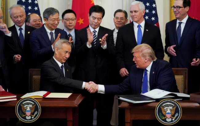 사진은 현지시간 15일 트럼프 대통령(오른쪽)과 중국의 류허 부총리(왼쪽)가 1단계 무역합의에 서명에 앞서 악수를 하는 모습.