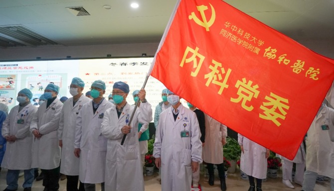 지난 22일(현지시간) 중국 후베이성 우한의 화중기술과학대학 통지의학원 병설 유니온 병원에서 의료진이 신종 코로나바이러스인 '우한 폐렴'과의 전쟁 선포식에 참석해 병원 깃발을 흔들고 있다. 사진=뉴시스