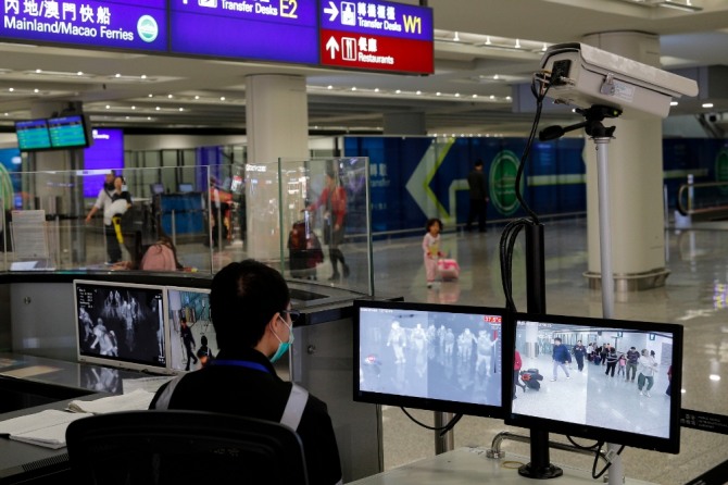 홍콩국제공항 입국장에서 한 보건 관계자가 입국 승객들을 살펴보고 있다. 사진=뉴시스