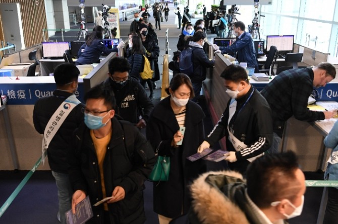 중국발 항공기에서 내린 여행객들과 외국인들이 28일 인천국제공항 제1터미널 입국장 검역소에서 발열검사를 받고 있다.사진=뉴시스