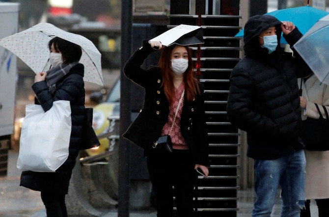 일본 됴쿄 쇼핑 거리에서 중국인 관광객들이 마스크를 쓴 채 신호등을 기다리고 있다. 사진=로이터