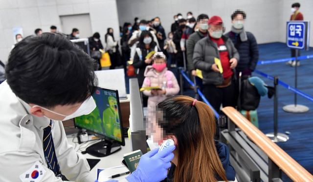 중국발 항공기를 타고 온 승객들이 김해국제공항 국제선 입국장에서 체온 감지 열화상카메라가 설치된 검역대를 지나고 있다.사진=뉴시스