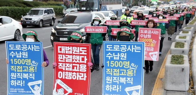 민주노총 톨게이트노조 조합원들이 2019년 11월 12일 서울 광화문광장에서 요금수납원 직고용을 촉구하는 행진을 하고 있다. 사진=뉴시스  