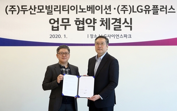 LG유플러스의 두산모빌리티이노베이션과의 업무협약 체결식에서 LG유플러스 조원석 기업신사업그룹장 전무(왼쪽)와 두산모빌리티이노베이션 이두순 대표가 기념 촬영하고 있는 모습. 사진=LG유플러스