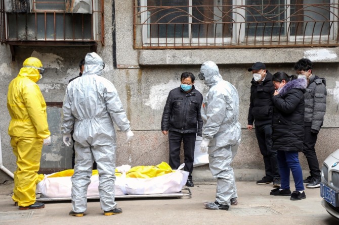 ] 1일 중국 후베이성 우한에서 신종 코로나 바이러스 감염증의 사망자 시신을 장의업 직원들이 옮기고 있다. 1월9일 첫 사망자가 나왔던 우한시 희생자 수가 1일 자정까지 220명을 육박했다. 사진=뉴시스