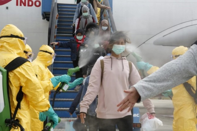 의료진들이 신종 코로나 바이러스 전염병을 막기 위해 중국 우한에서 온 인도네시아 국민들에게 방역을 하고 있다. 사진=로이터