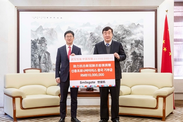 2월 5일 중국대사관에서 열린 전달식에서 양동기 스마일게이트 대외담당 사장(좌측)이 싱하이밍 주한 중국대사(우측)에게 천만 위안의 성금을 전달하고 있다. 사진=스마일게이트