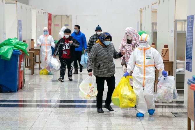 지난 5일(현지시간) 중국 후베이성 우한의 한 전시장을 개조한 임시병원에 신종 코로나바이러스 감염증(우한 폐렴) 환자들이 의료진의 도움으로 입원하고 있다. 현지 관계자는 우한시에서 전시장을 개조한, 1600병상 규모의 첫 임시 병원이 신종 코로나 환자를 받기 시작했다고 전했다. 사진=뉴시스