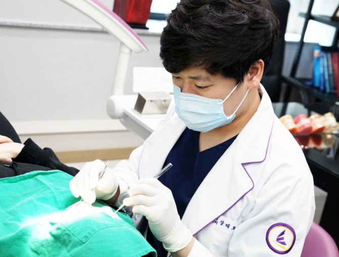 장태호 청주 이끌림치과 원장은 치아교정은 부정교합으로 인해 유발될 수 있는 각종 구강 질환을 예방할 수 있다. 다만 치아교정을 진행하기에 앞서 정확한 검사와 철저한 계획이 수립돼야 한다. 이를 위해 치아교정에 대한 경험과 노하우가 풍부한 전문의가 있는 교정치과를 선택해야 한다고 설명했다. 장태호 원장이 환자를 치료하고 있다. 사진=청주 이끌림치과