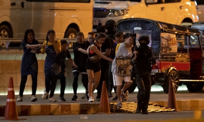 8일(현지시간) 군인 1명의 총기 난사 사건이 발생한 태국 방콕에서 북동쪽 250㎞ 떨어진 나콘랏차시마시의 대형쇼핑몰에서 시민들이 태국 특수부대의 안내를 받고 급하게 건물 밖으로 대피하고 있다. 범인은 쇼핑몰에서 인질극을 벌이며 군경과 대치하다 사살됐다. 사진=AP/뉴시스