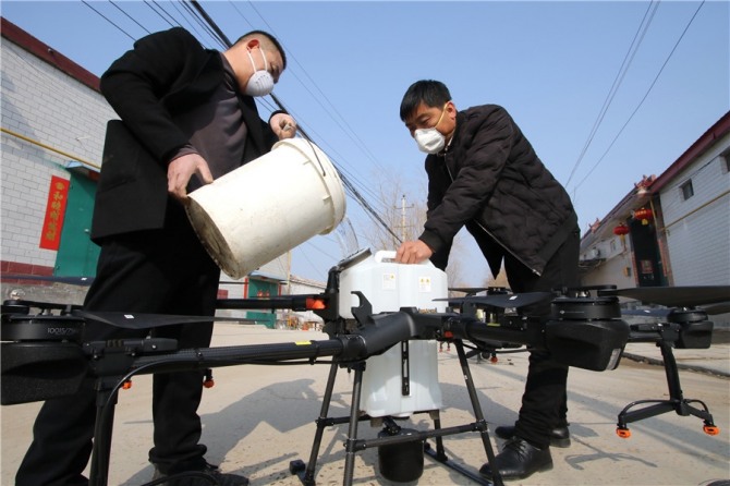중국 허베이성 한단의 청완 마을에서  의료요원들이 지난달 31일 드론 탱크에 소독제를 쏟아넣고 있다. 사진=차이나데일리