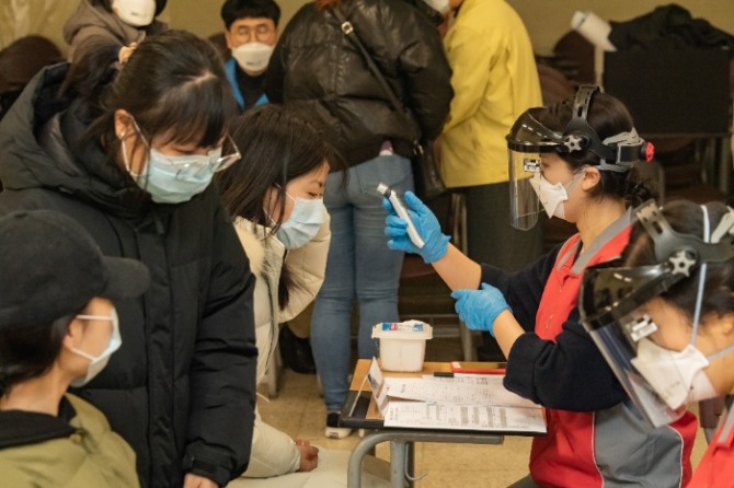 귀국 유학생들이 지난 12일 서울 세종대학교 광개토관에 마련된 임시 선별진료소에서 신종 코로나 바이러스 감염증(COVID-19) 2차 검진을 받기 전 체온을 측정하고 있다.사진=뉴시스