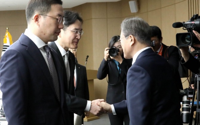 문재인 대통령(오른쪽)이 13일 서울 중구 대한상공회의소에서 열린 '신종 코로나바이러스 감염증(코로나19)' 대응 경제계 간담회에 참석해 이재용 삼성전자 부회장과 악수하고 있다. 왼쪽은 구광모 LG그룹 회장. 사진=뉴시스