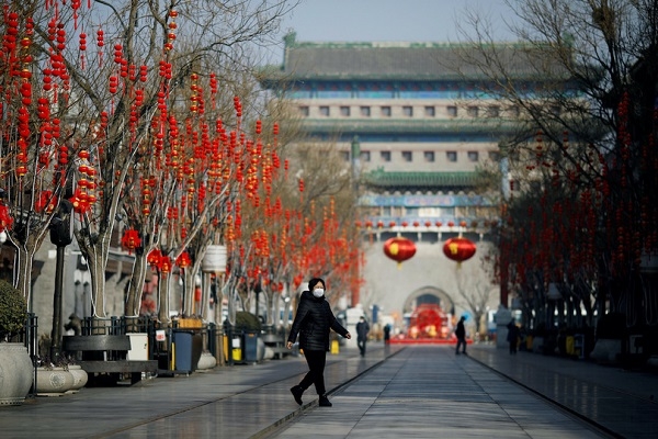 한 베이징 여성이 코로나19의 영향으로 마스크를 한 채 거리를 걷고 있다. 사진=로이터