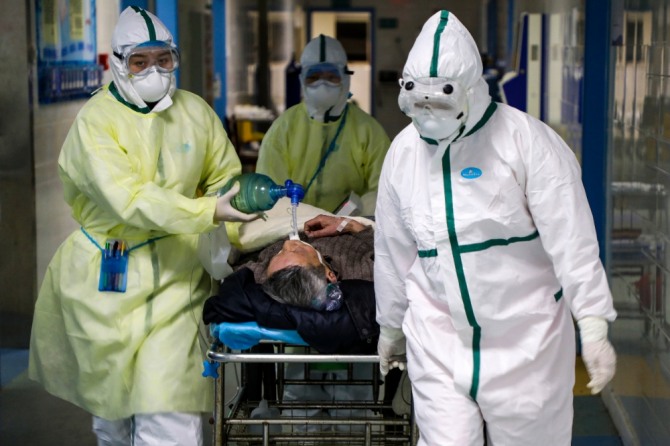 중국 후베이성 우한의 한 병원에서 지난 6일 보호복을 입은 의료진이 코로나19 환자를 격리병동으로 옮기고 있다. 사진=뉴시스