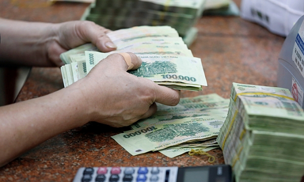 한 베트남 은행원이 10만동 지폐를 세고 있는 모습. 사진=로이터