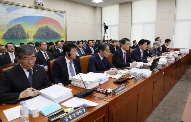 윤석헌 금융감독원장(왼쪽 앞줄 첫번째)이 국회 정무위원회 업무보고에 참석해 관련 자료를 살펴보고 있다. 사진=뉴시스