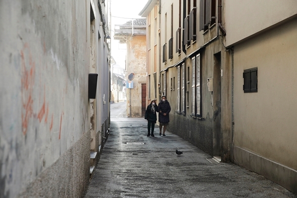 신종 코로나 바이러스 감염증 사망자가 발생해 봉쇄된 이탈리아 코도뇨에서 22일(현지시간) 두 여성이 마스크를 쓴 채 텅빈 골목길을 걸어가고 있다. 사진=코도뇨, AP/뉴시스