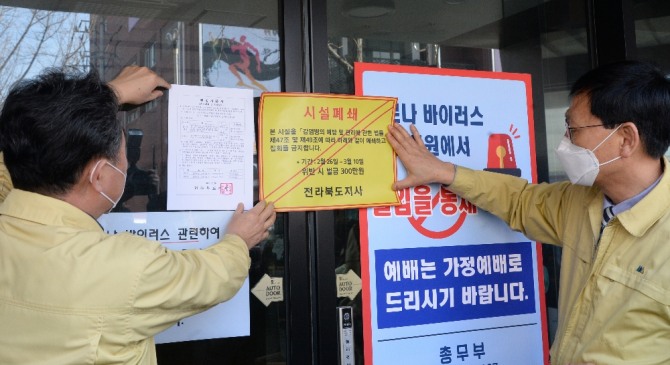 26일 전북 전주시 신천지 하늘문화센터에서 전라북도 관계자들이 '감염병 예방 및 관리에 관한 법률'의 행정명령을 집행해 시설을 폐쇄하고 스티커를 붙이고 있다. 사진=뉴시스