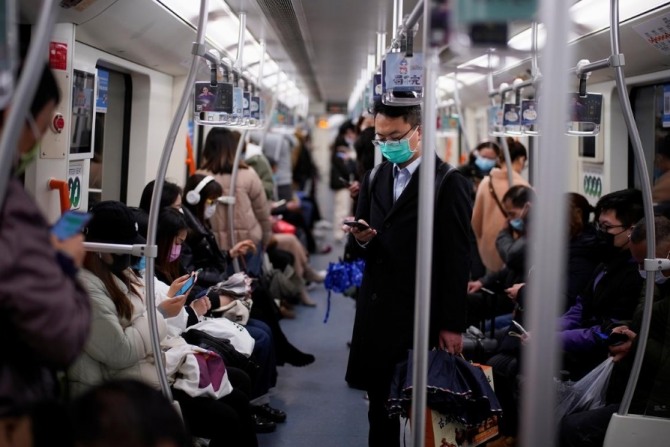 신종코로나바이러스(코로나19) 감염증이 확산하고 있는 중국 상하이 지하철 열차 안에서 시민들이 마스크를 낀 채 스마트폰을 보고 있다. 사진=로이터통신