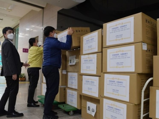 부산시 직원들이 중국 산둥성으로부터 받은 의료용 마스크 상자를 정리하고 있다. 사진=뉴시스