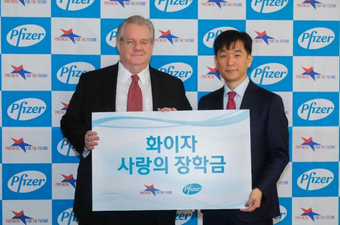 오동욱(오른쪽) 한국화이자제약 사장과 제프리 존스 미래의동반자재단 이사장이 '2020 화이자 사랑의 장학금' 전달식에서 기념촬영을 하고 있다. 사진=한국화이자제약