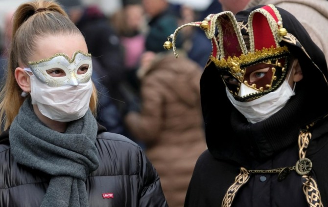 지난 23일(현지시간) 이탈리아 베니스에서 열린 베니스 축제에 참가한 시민들이 마스크를 쓴 채 서 있다. 사진=로이터