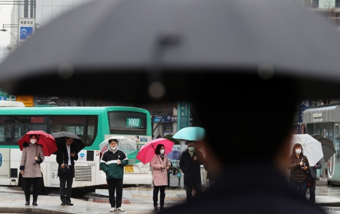 시민들이 우산을 쓰고 신호를 기다리고 있다.  사진=뉴시스