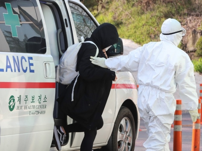 지난 24일 제주대학교병원 음압병동에 코로나19 양성 판정을 받은 20대 여성이 이송되고 있다. 사진=뉴시스