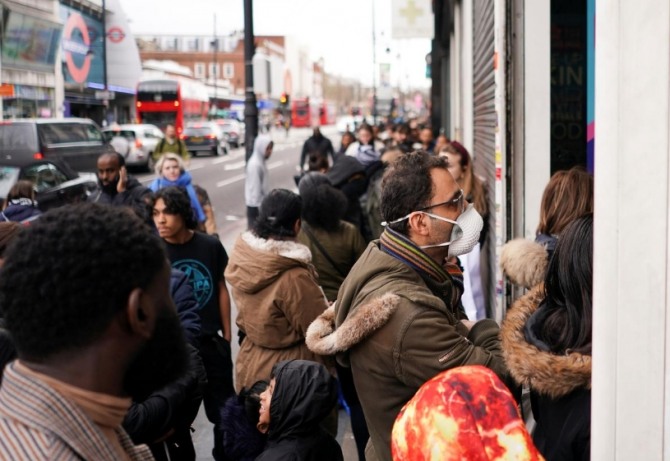 지난 15일 영국 런던 시내의 한 약국 앞이 시민들로 장사진을 이루고 있다. 사진=로이터