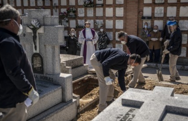 지난달 28일 스페인 마드리드의 한 묘지에서 코로나19로 사망한 노인의 시신이 안장되고 있다.